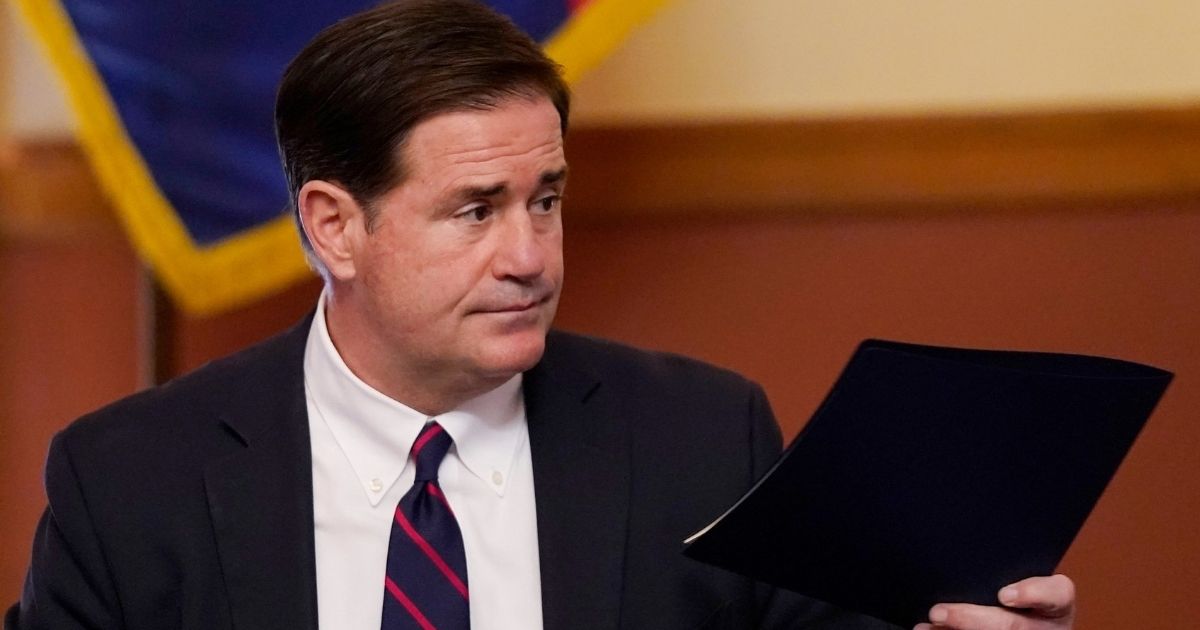 Arizona GOP Gov. Doug Ducey signs and hands off election results to certify the federal, statewide and legislative offices in Phoenix, Arizona, on Nov. 30, 2020.