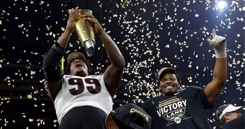 Georgia defensive tackle Jordan Davis celebrates with the national championship trophy after the Bulldogs defeated the Alabama Crimson Tide 33-18 at Lucas Oil Stadium in Indianapolis on Monday night.