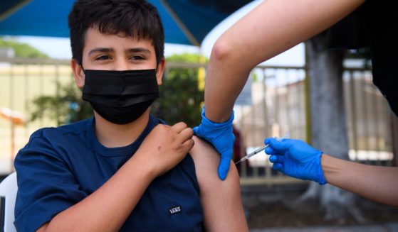 Simon Huizar, 13, receives a Pfizer COVID-19 vaccine at a mobile vaccination clinic at the Weingart East Los Angeles YMCA in this file photo from May 2021. Under a proposed new law, California children 12 and older could get vaccinated without parental permission.