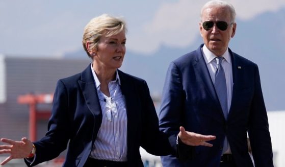 Energy Secretary Jennifer Granholm talks to President Joe Biden in this file photo from a tour of the National Renewable Energy Laboratory in Arvada, Colorado, in September. Granholm reportedly violated federal law by failing to properly disclose stock sales, according to news reports.