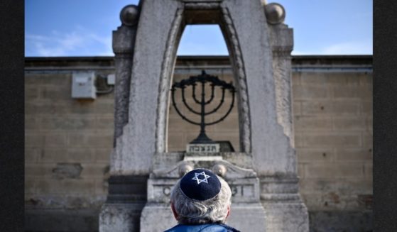 A man prays in front of a Jewish tomb Jan. 27 in Turin, Italy. International Holocaust Remembrance Day was observed in many countries worldwide this week to mark the 77th year since the liberation of the Auschwitz concentration camp.
