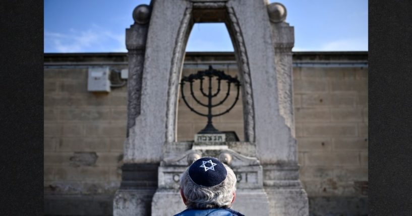 A man prays in front of a Jewish tomb Jan. 27 in Turin, Italy. International Holocaust Remembrance Day was observed in many countries worldwide this week to mark the 77th year since the liberation of the Auschwitz concentration camp.