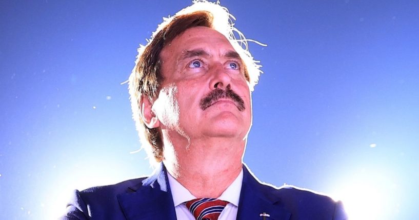 My Pillow CEO and conservative political activist Mike Lindell listens to former President Donald Trump as he addresses supporters during a rally at York Family Farms in Cullman, Alabama, on on Aug. 21.