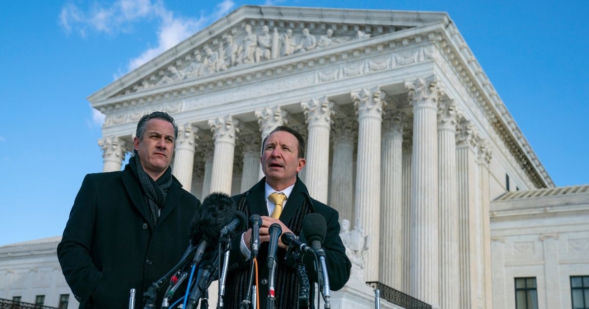Louisiana Attorney General Jeff Landry talks to reporters outside the Supreme Court Friday after arguments about whether to allow the administration to enforce a vaccine-or-testing requirement that applies to large employers and a separate vaccine mandate for most health care workers. At left is deputy Louisiana Attorney General Bill Stiles.