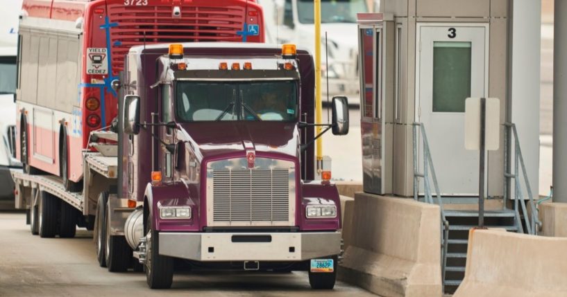 A trucker waits at the Canadian customs booth in Sarnia, Ontario, in this file photo from March 2020. Vaccination mandates by both the Canadian and US governments going into effect this month promise to further disrupt the supply chain and drive food prices even higher.