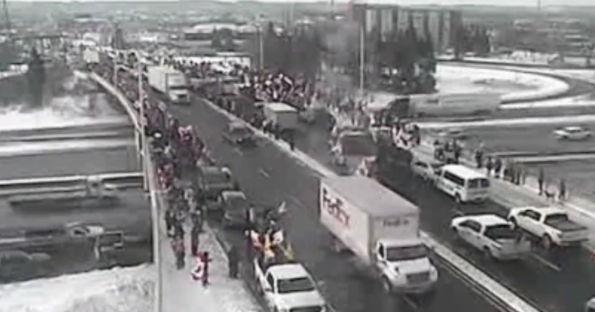 A convoy of truckers, 43 miles long, is driving through Canada on their way to Ottawa in order to protest the truck driver vaccine mandate. The convoy is seen on here, being greeted by hundreds of supporters, as it drives through Ontario.