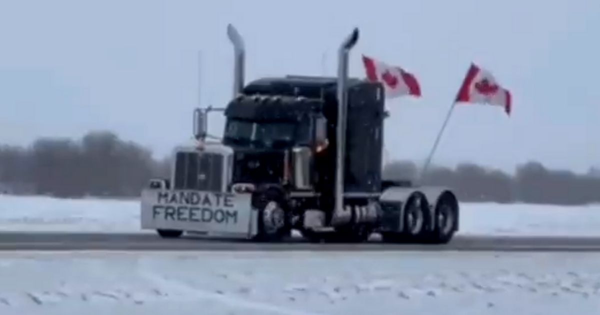 A truck bearing Canadian flags and a sign that reads "Mandate Freedom" takes part in a protest at the U.S.-Canadian border.
