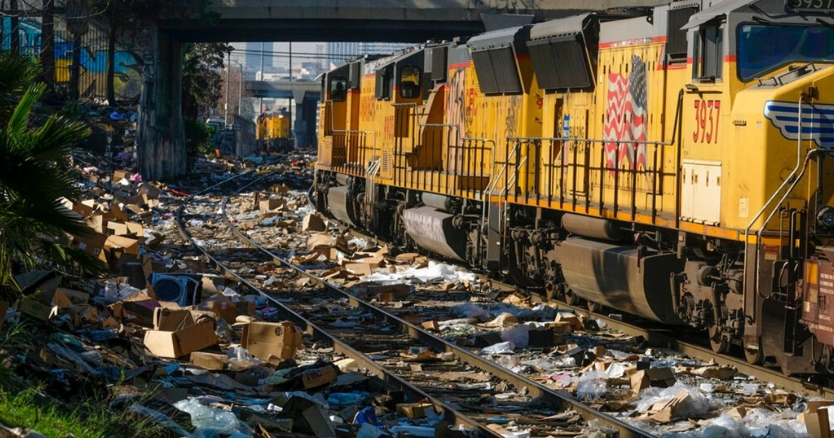 A train passes by shredded boxes and packages at a section of the Union Pacific train tracks in downtown Los Angeles Jan. 14. Thieves have been raiding cargo containers aboard trains nearing downtown Los Angeles for months, leaving the tracks blanketed with discarded packages. Now Los Angeles police have reported that the thefts include shipments of firearms.