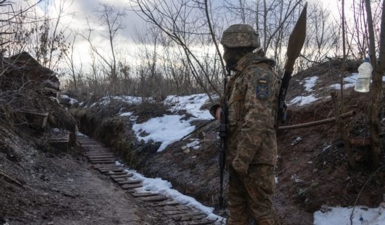 A Ukrainian marine walks in a trench at the line of separation from pro-Russian rebels in the Donetsk region, Ukraine, on Jan. 7, 2022.