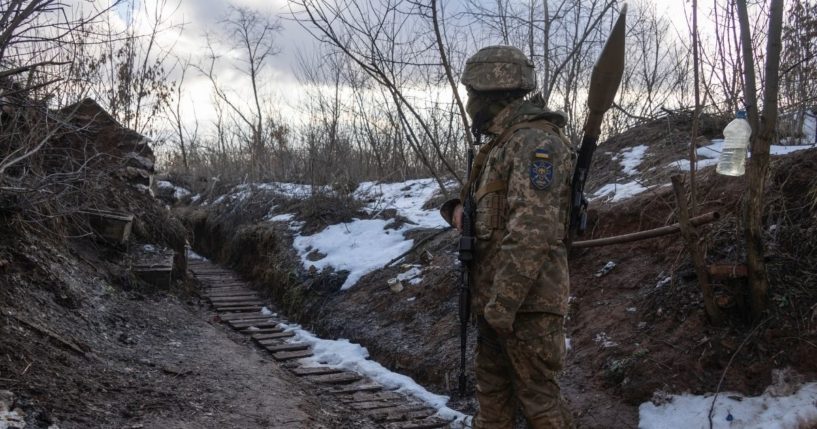 A Ukrainian marine walks in a trench at the line of separation from pro-Russian rebels in the Donetsk region, Ukraine, on Jan. 7, 2022.
