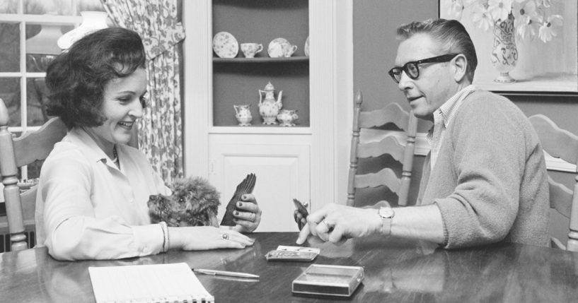 Betty White and her husband, Allen Ludden, play cards in their home in Westchester, New York, in 1965. White died on New Year's Eve at the age of 99.