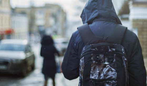 Image of teen wearing school backpack.
