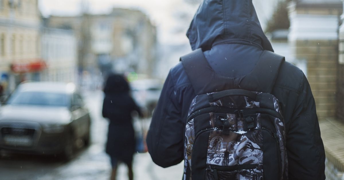 Image of teen wearing school backpack.