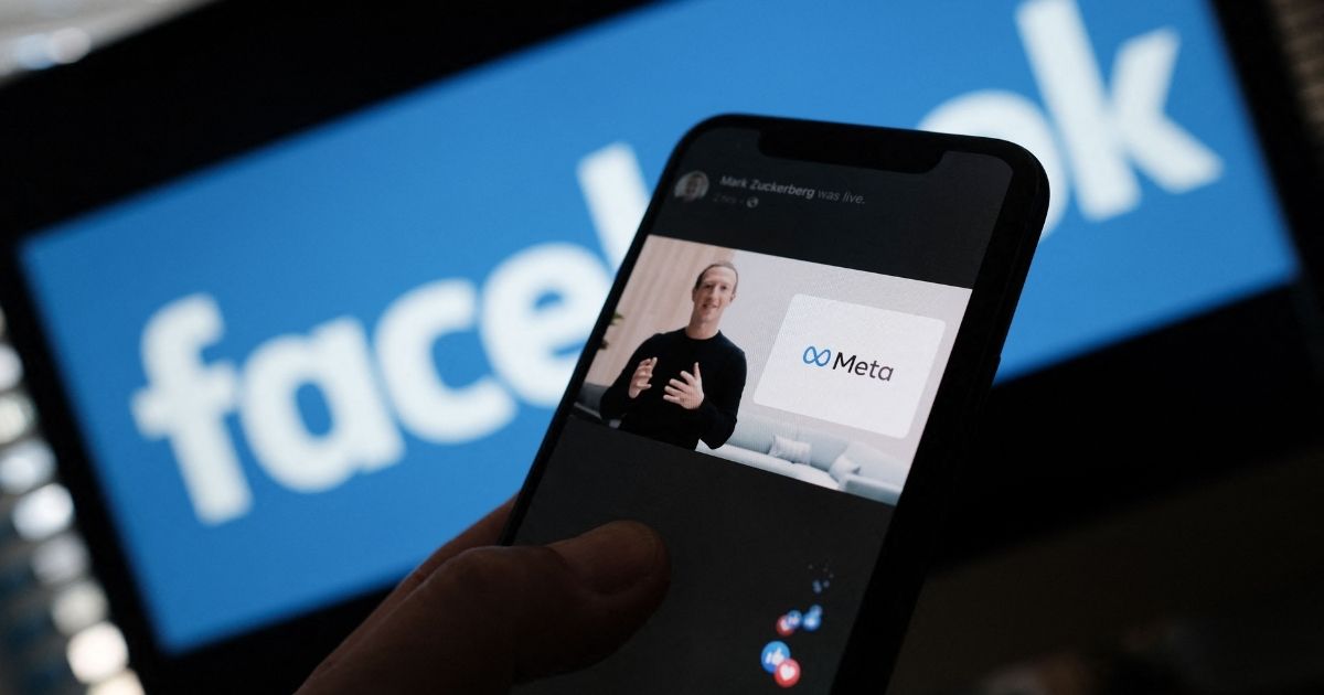 In this illustration photo taken in Los Angeles on Oct. 28, 2021, a person watches on a smartphone as Facebook CEO Mark Zuckerberg unveils the Meta logo. Zuckerberg announced the parent company's name is being changed to 'Meta' to represent a future beyond its social network.