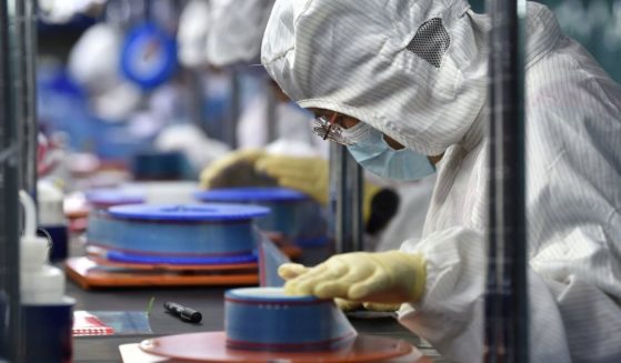 Workers manufacture adhesive tapes for flexible printed circuits at a factory in Yancheng in China's eastern Jiangsu province in September.