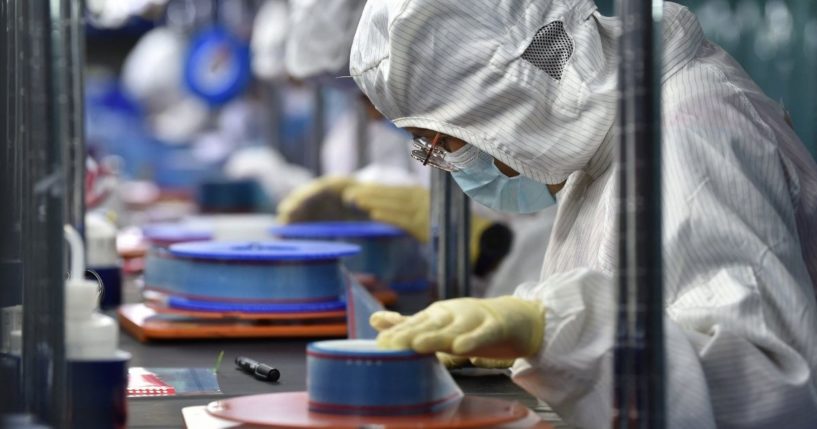 Workers manufacture adhesive tapes for flexible printed circuits at a factory in Yancheng in China's eastern Jiangsu province in September.