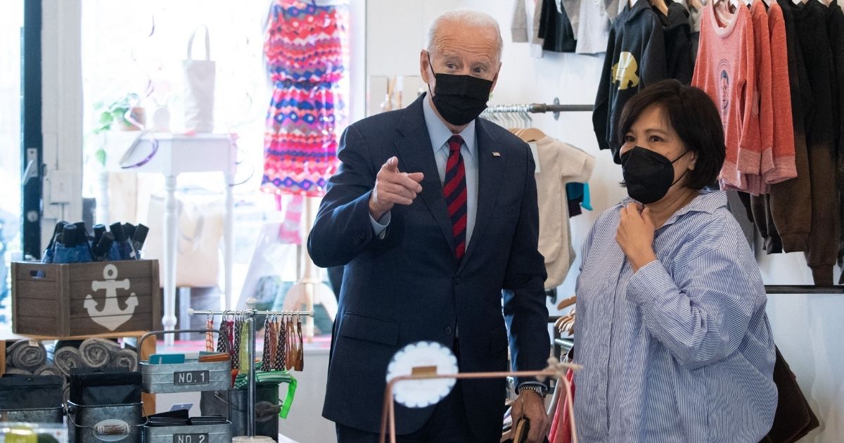 With the likelihood of a Russian invasion of Ukraine rising, President Joe Biden shops for gifts Tuesday during a visit to Honey Made, a small business owned by Viboonrattana "Moo" Honey, right, in Washington.