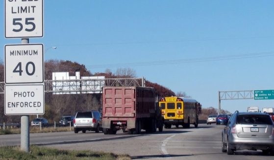 In a 2013 file photo, vehicles pass a highway sign along Interstate 380 in Cedar Rapids, Iowa, alerting drivers that the 55-mph speed limit is enforced by speed cameras.
