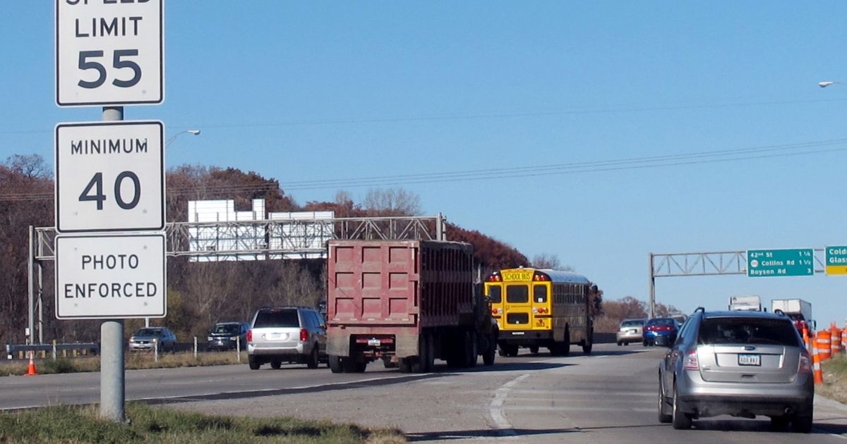 In a 2013 file photo, vehicles pass a highway sign along Interstate 380 in Cedar Rapids, Iowa, alerting drivers that the 55-mph speed limit is enforced by speed cameras.