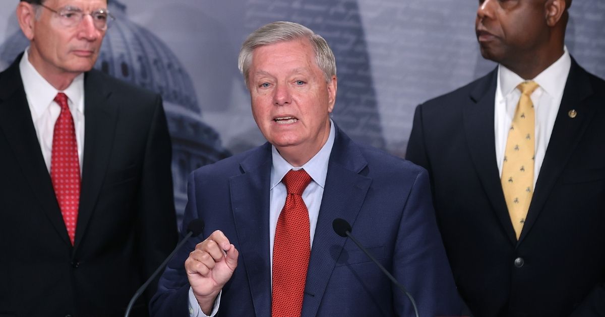 Sen. Lindsey Graham, flanked by Sens. John Barrasso of Wyoming, left, and Tim Scott of South Carolina, right, at a July 2021 news conference.