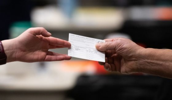 A patient receives a card showing when they received their first dose of the Pfizer COVID-19 vaccine at the Amazon Meeting Center in downtown Seattle, Washington, on Jan. 24, 2021.
