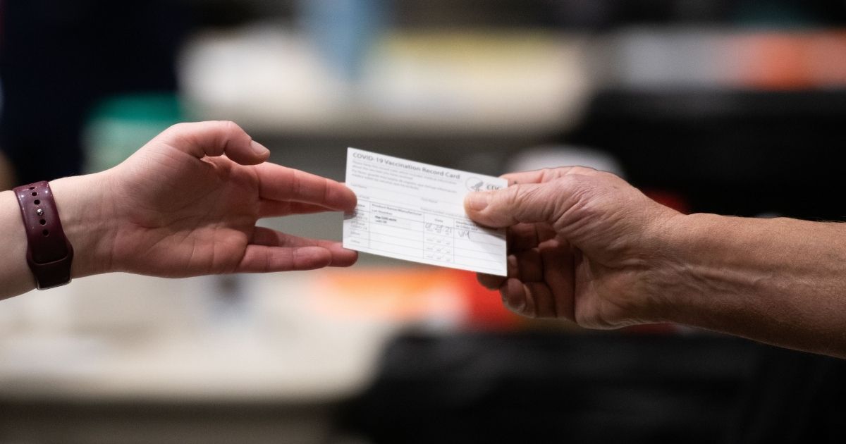 A patient receives a card showing when they received their first dose of the Pfizer COVID-19 vaccine at the Amazon Meeting Center in downtown Seattle, Washington, on Jan. 24, 2021.