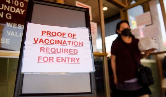 A sign stating proof of a COVID-19 vaccination is required is displayed outside of Langer's Deli in Los Angeles on Aug. 7.