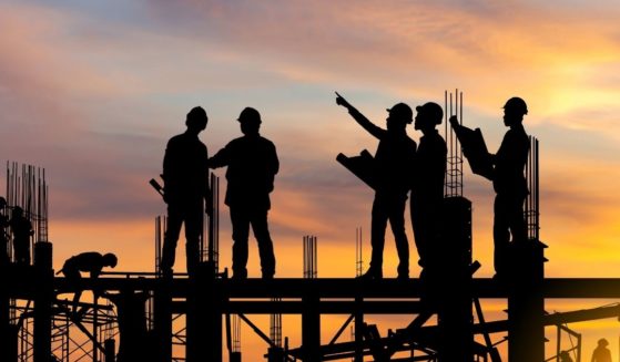 Construction workers are seen in this stock image.