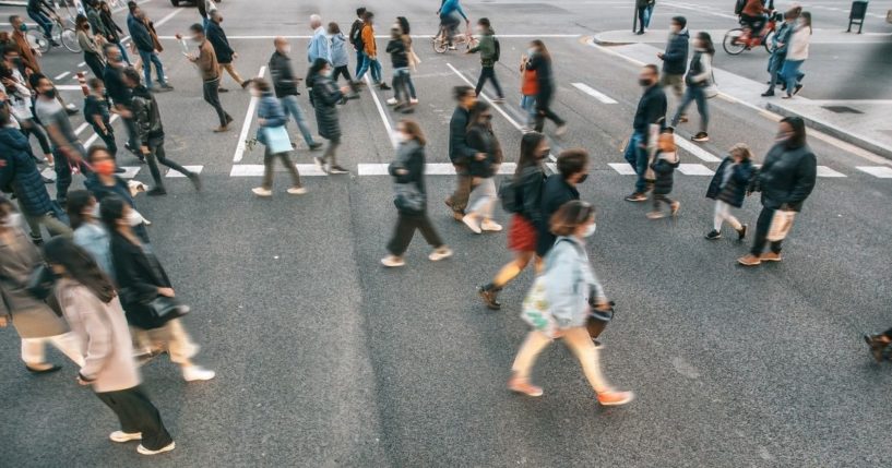 People walk across a street in this stock image.