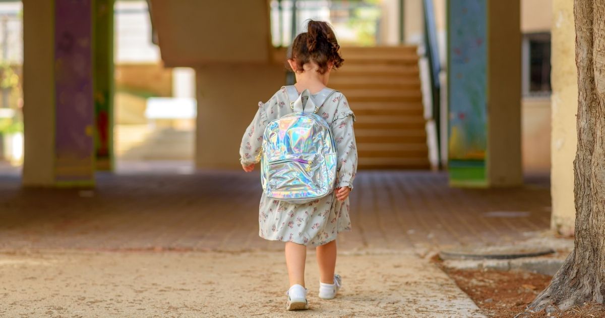 A girl wearing a backpack is seen in the above stock image.