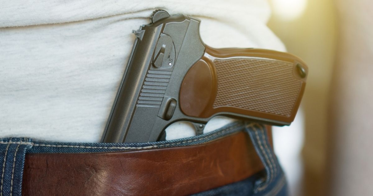 A man carries a gun in this stock image.