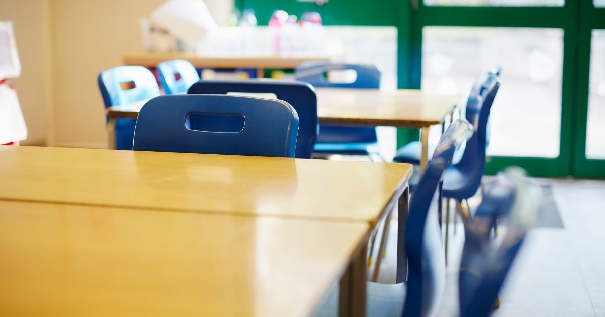 An empty elementary school classroom is seen in the above stock image.