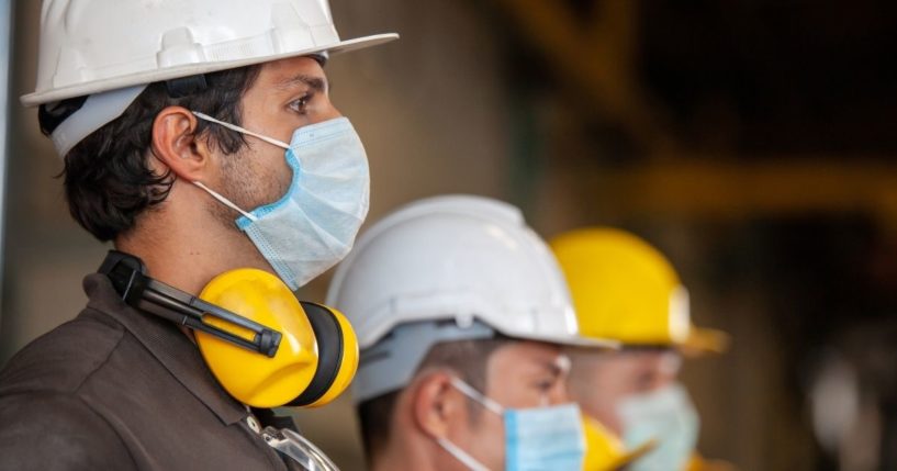 Workers wear masks in this stock image.