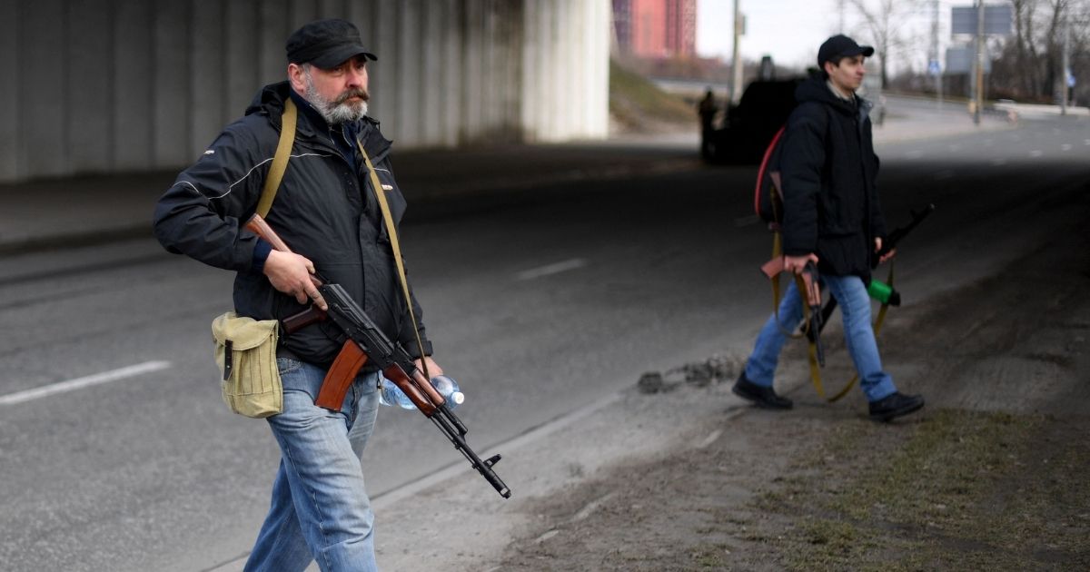 Volunteers carrying rifles protect a main road leading into Kyiv on Friday.