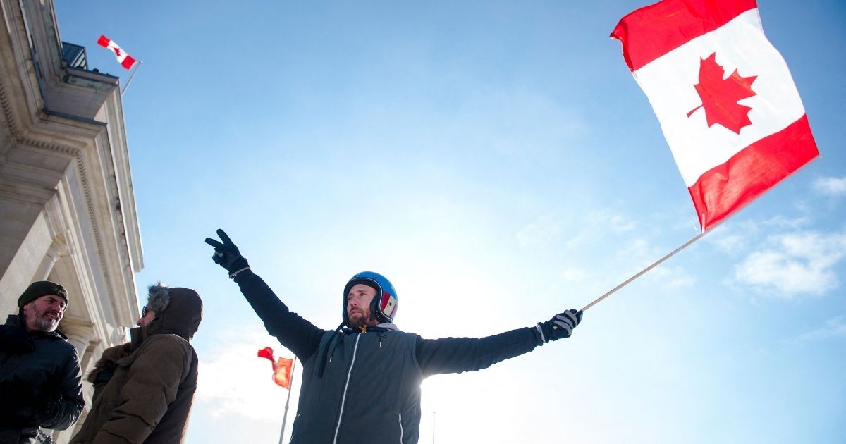 A protester waves a Canadian flag during a standoff with police in Ottawa, Canada, on Friday.
