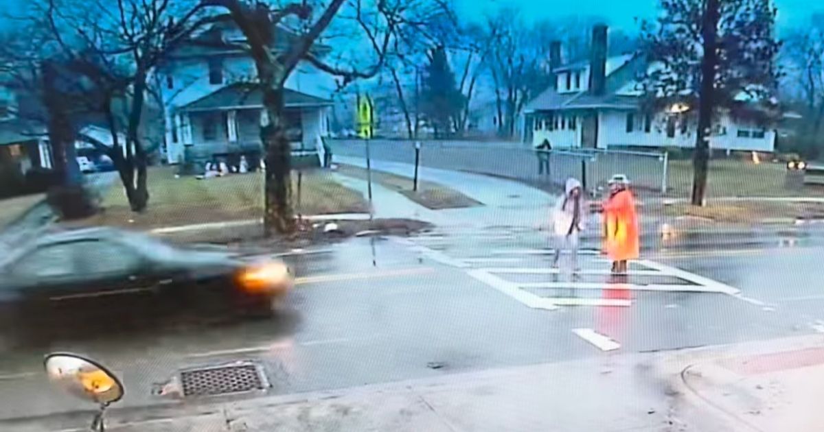 A car fast approaches North East Police Department Cpl. Annette Goodyear and a student in a crosswalk in Cecil County, Maryland.