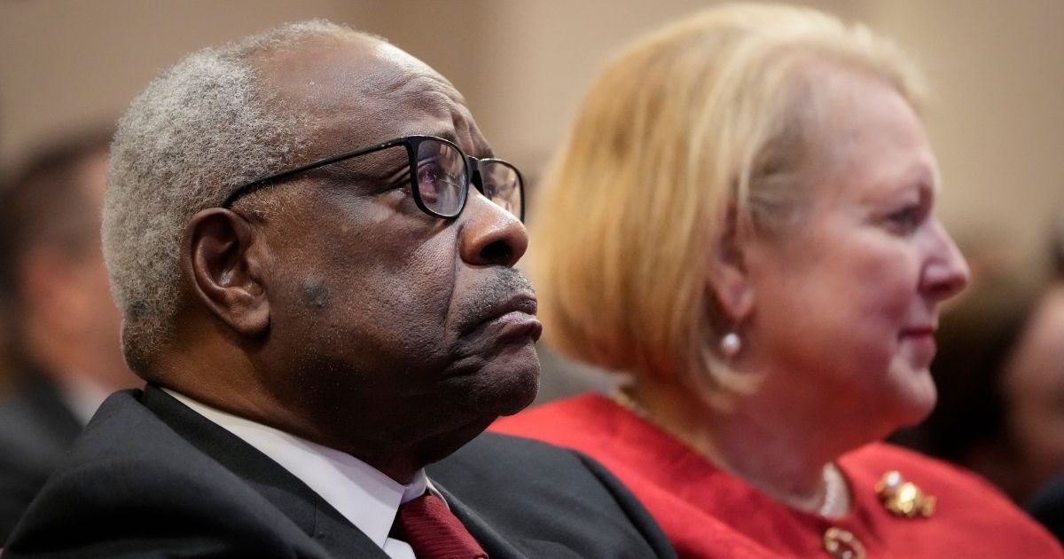 Supreme Court Justice Clarence Thomas sits with his wife, Virginia, while he waits to speak at the Heritage Foundation in Washington on Oct. 21.