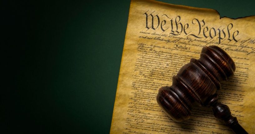 This stock image shows the U.S. Constitution with a gavel sitting atop it. Seventeen states have now passed resolutions calling for a convention of states to propose amendments to the Constitution.