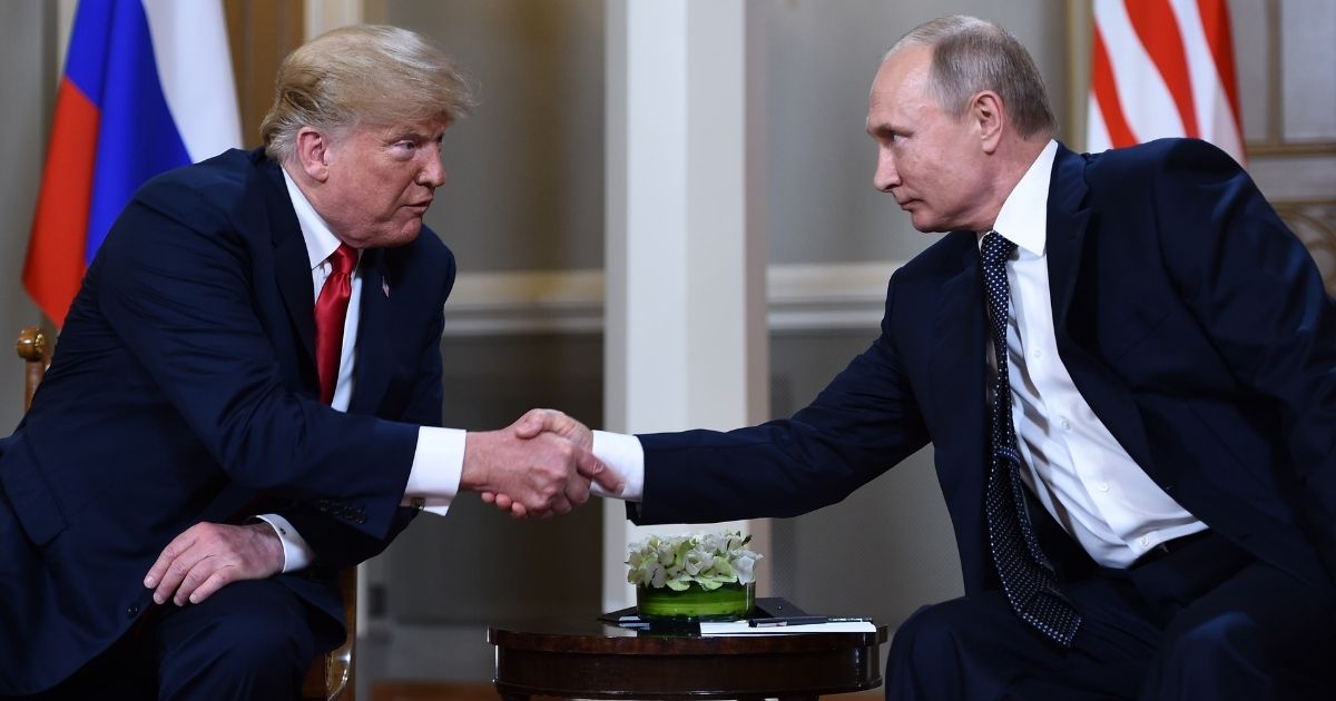 Former U.S. President Donald Trump, left, and Russian President Vladimir Putin shake hands before a meeting in Helsinki, Finland, on July 16, 2018.