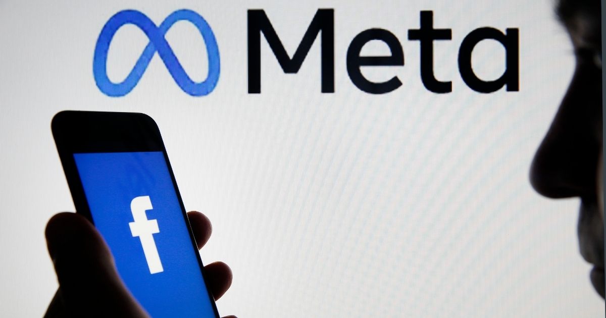 The Facebook logo is displayed on the screen of an iPhone in front of a Meta logo on Oct. 29, 2021, in Paris.