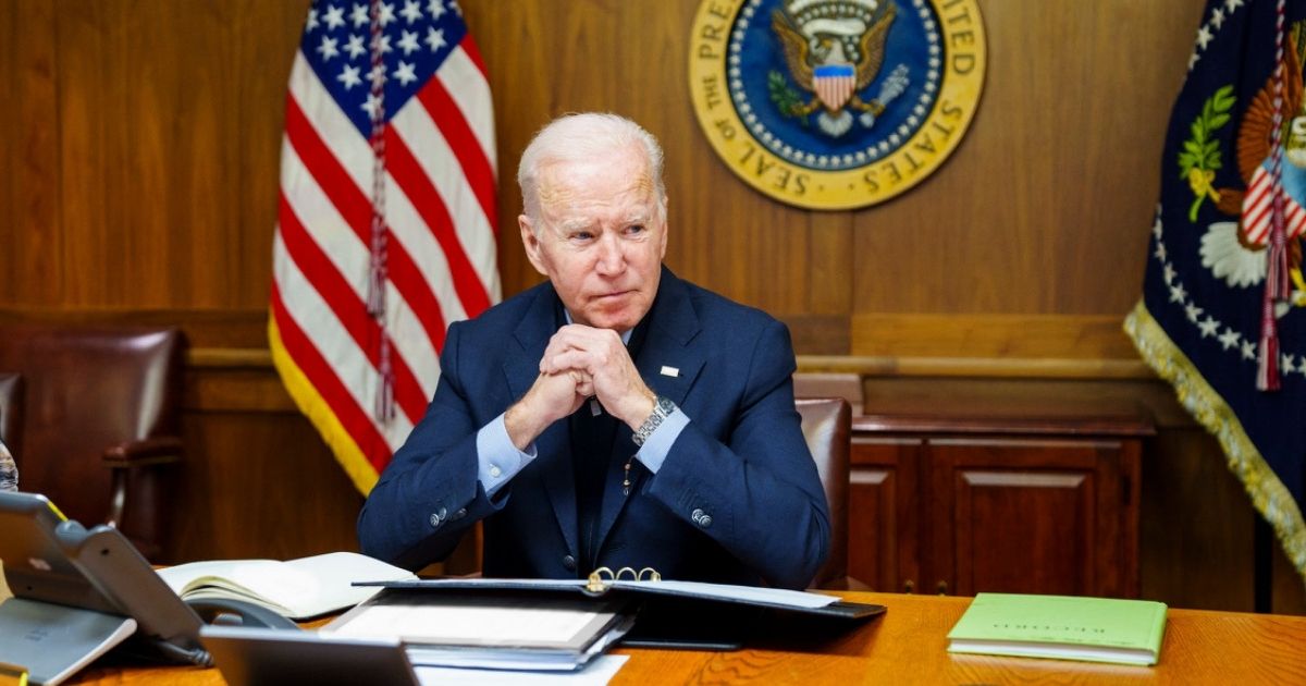 President Joe Biden sits at a desk at Camp David, Maryland, on Saturday as he works to come up with a solution to the Russia-Ukraine crisis.