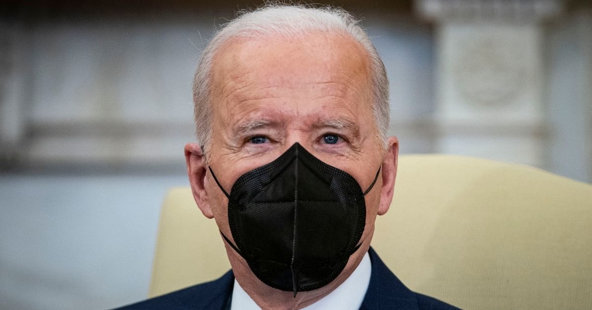 President Joe Biden wears a mask while speaking to reporters in the Oval Office at the White House in Washington on Feb. 7.