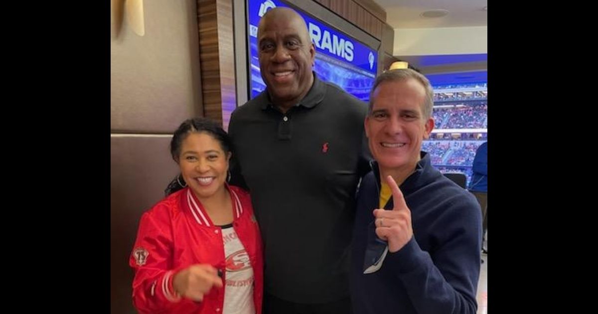 San Francisco Mayor London Breed, left, and Los Angeles Mayor Eric Garcetti, right, pose maskless with NBA legend Magic Johnson during the NFC championship game Sunday in LA.