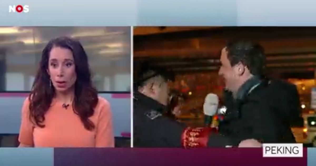 A stunned news anchor looks on, left, as a Dutch journalist's live broadcast is interrupted by a black-coated Chinese security guard, who grabs the man and tries to pull him off camera.