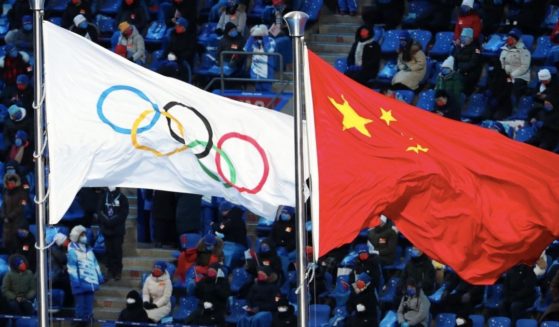 The Olympic and Chinese flags fly during the Opening Ceremony of the 2022 Winter Olympics at Beijing National Stadium on Friday in Beijing.