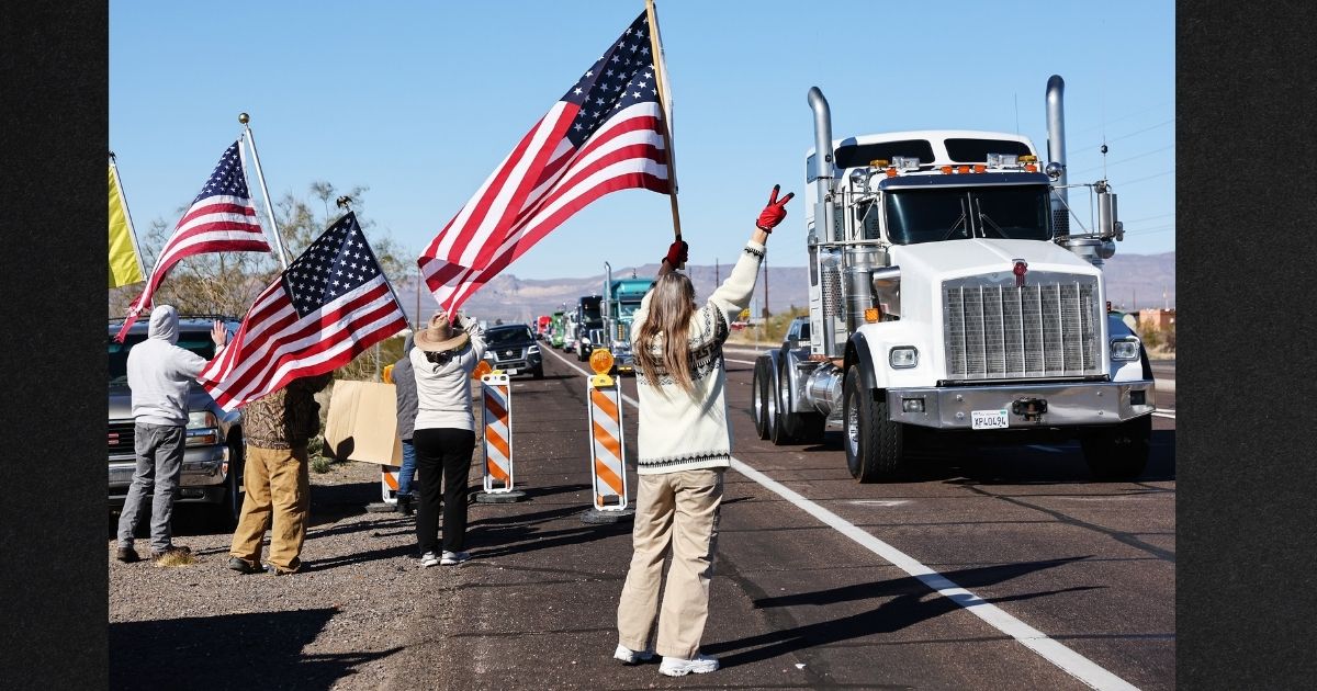 Supporters wave as participants in the 'People’s Convoy' pass through Golden Valley, Arizona, Thursday. The convoy set out on a cross-country trip Wednesday to protest COVID-19 mandates.