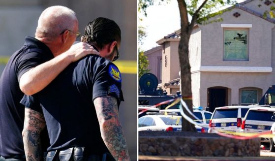 Police officers comfort one another in front of a house where several Phoenix Police Department officers were shot and four others were injured after responding to a shooting inside the home Friday.