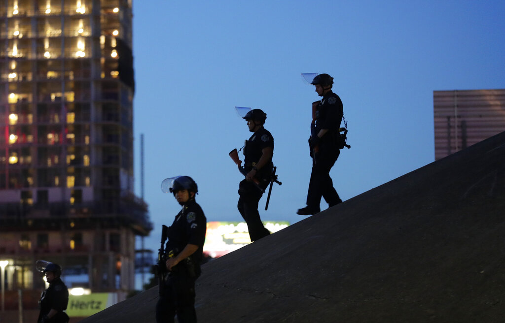 Police officers keep watch as demonstrators gather in downtown Austin, Texas, on June 4, 2020, as they protest the death of George Floyd. The Travis County district attorney is indicting 19 police officers on charges of excessive force against protesters in May of 2020.