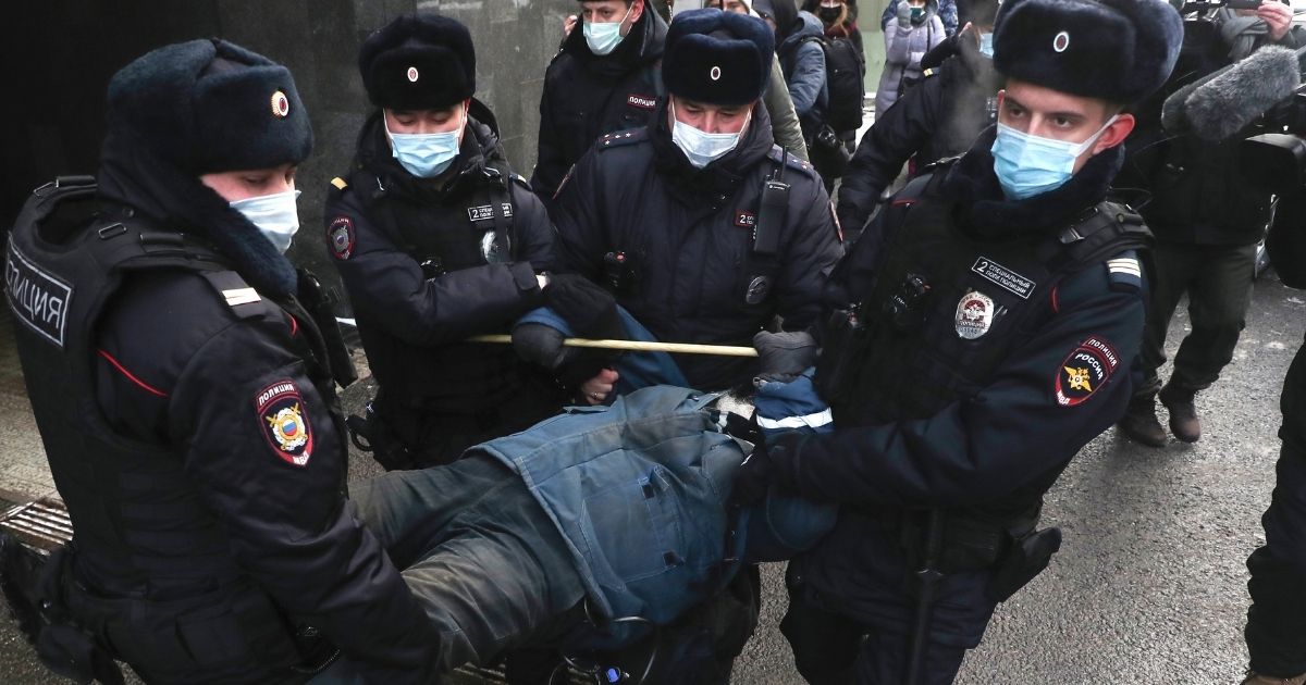 Police officers carry away a man who protested in front of the Supreme Court of the Russian Federation in Moscow on Dec. 28.