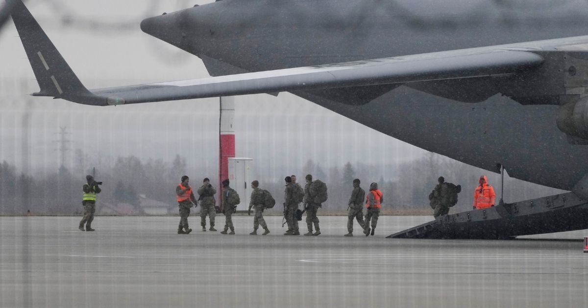 U.S. soldiers from the 82nd Airborne Division leave a plane with their equipment after landing at the Rzeszow-Jasionka airport in Poland on Sunday.
